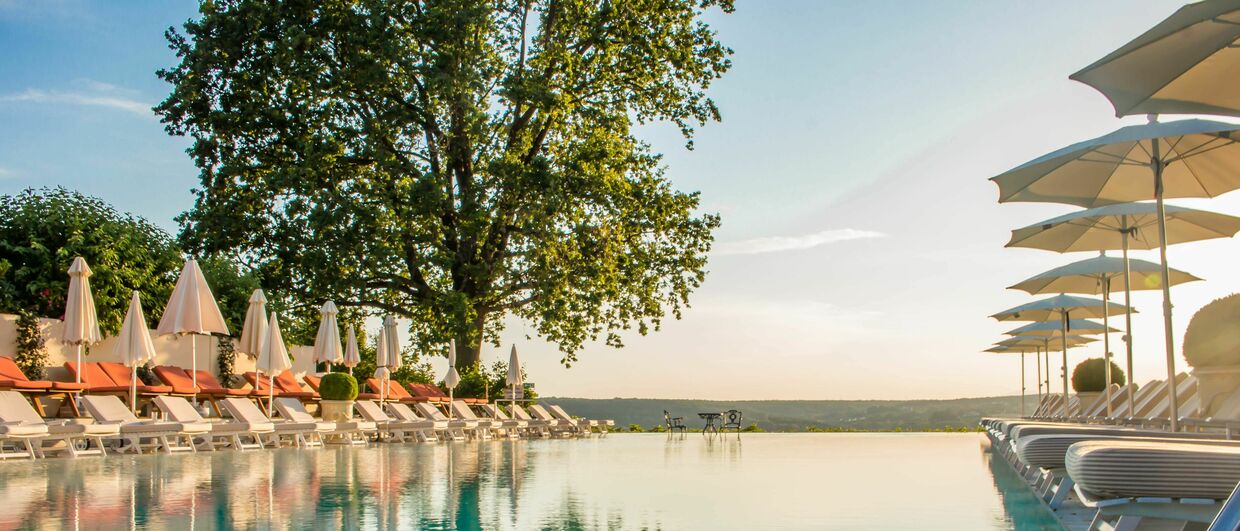 Im Außenbecken des Thermenhotels „Der Steirerhof“ schwimmen Gäste förmlich aufs oststeirische Hügelland zu.